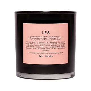A black glass vessel with light pink label containing the floral scented Les candle from Boy Smells