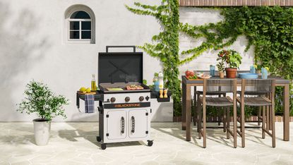 Walmart outdoor space with Blackstone bbq and wood table and chairs against limestone flooring