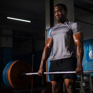 Muscular man lifting barbell in gym