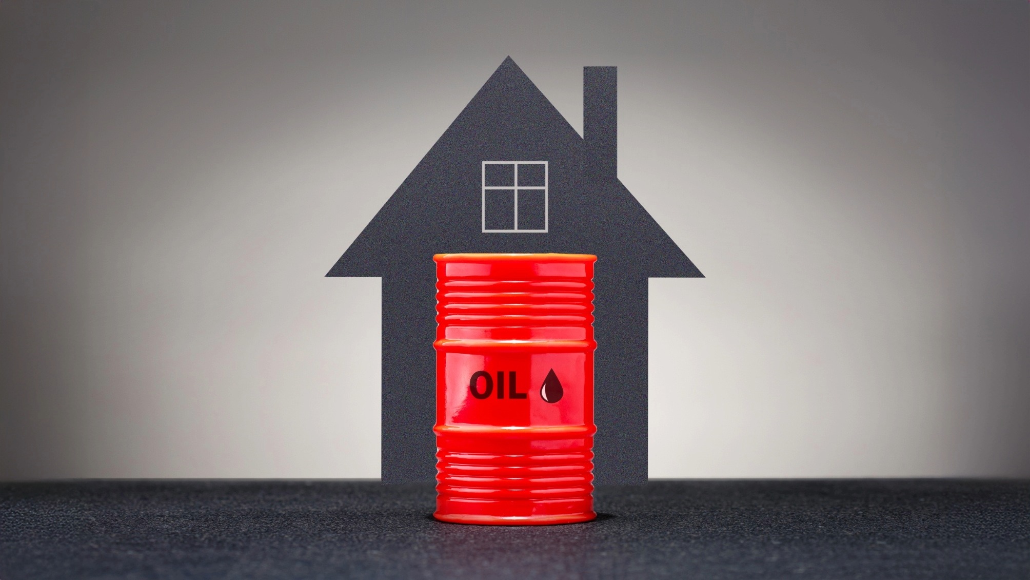 Graphic showing red barrel of oil in front of a grey background and the outline of a house. 