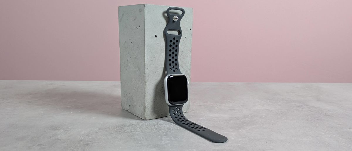 Upeak Sport Strap on Apple Watch, leaning on plinth on desk with pink background