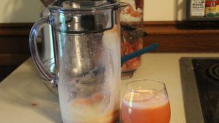Breville Juice Fountain Cold Plus with a glass of finished strawberry juice