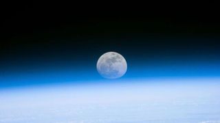 Astronauts aboard the Space Shuttle Discovery recorded this rarely seen phenomenon of the full Moon partially obscured by the atmosphere of Earth.