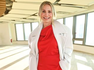 Cameron Diaz wearing a red dress and white coat at PFW