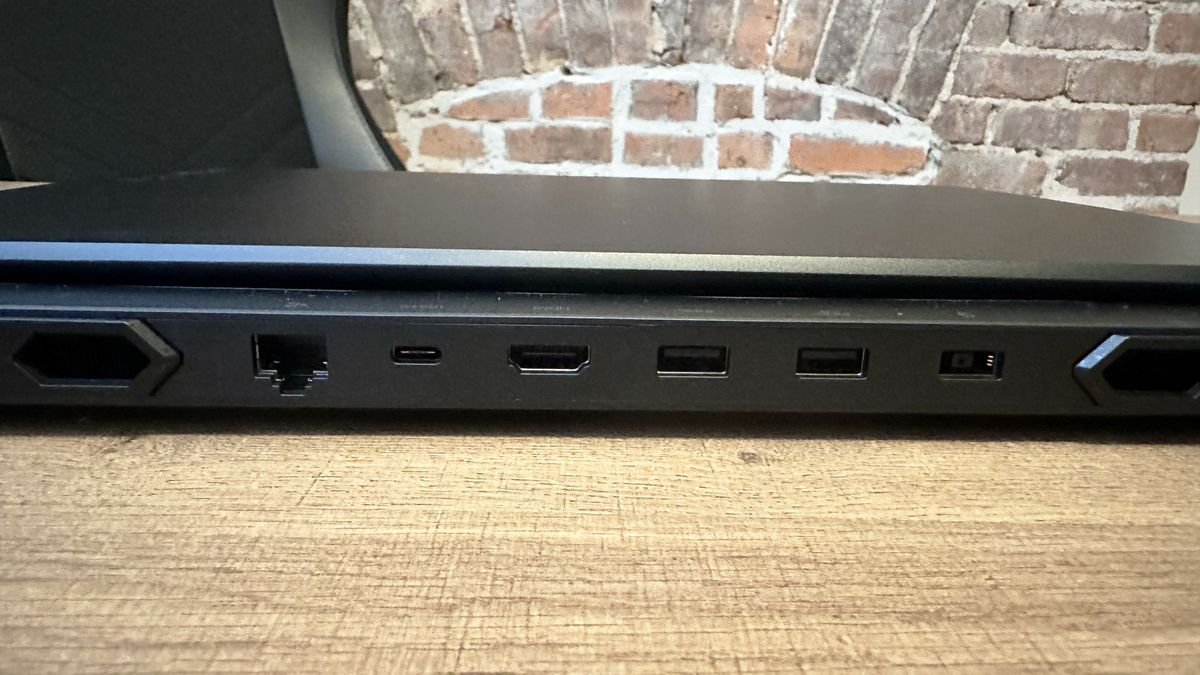 Lenovo Legion Pro 7i (Gen 9) closed on a wood table, highlight ports on the back, including USB Type-A, HDMI, USB Type-C, Ethernet, and power jack.