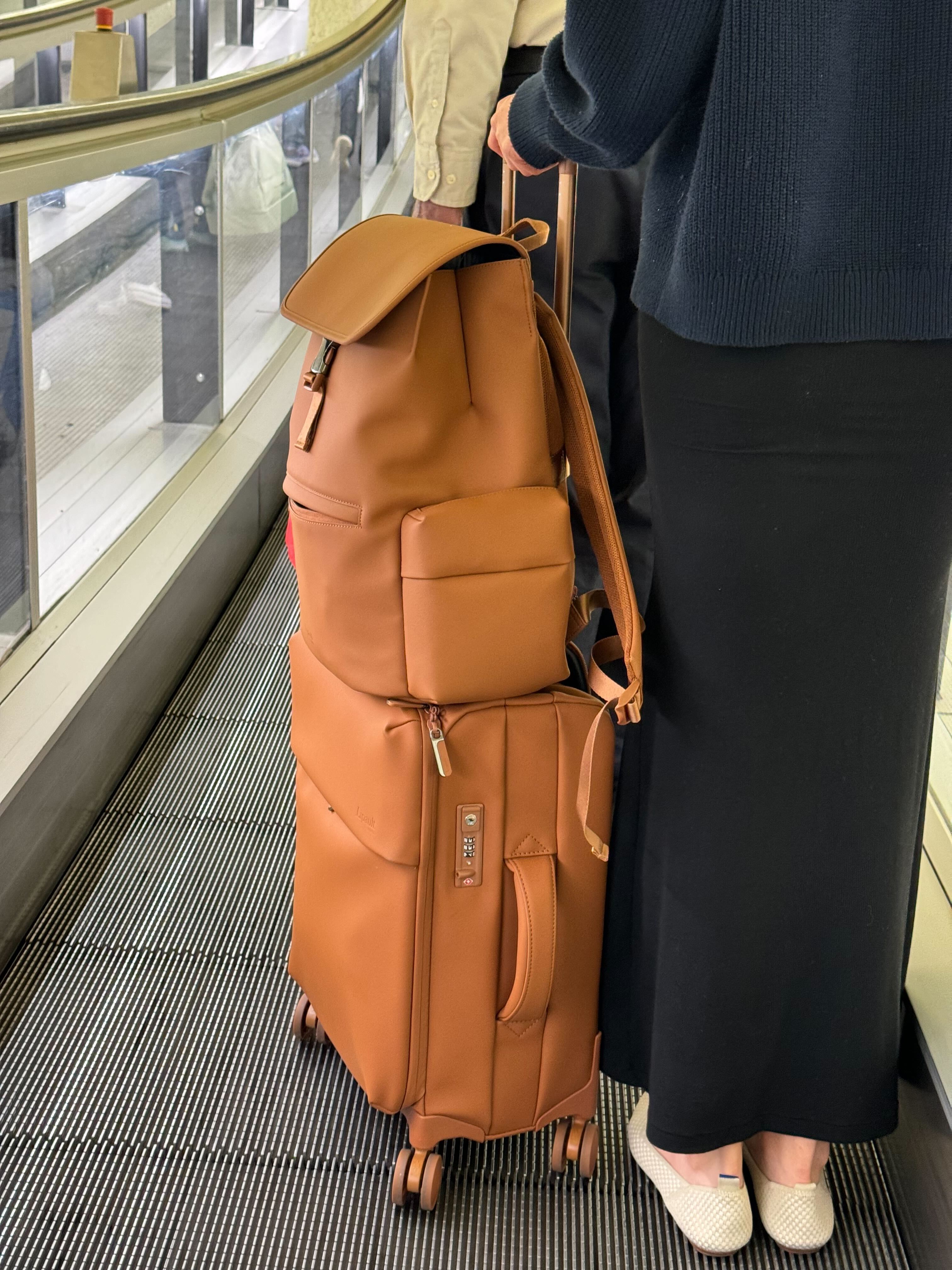 A traveler in CDG using a lipault backpack and luggage.