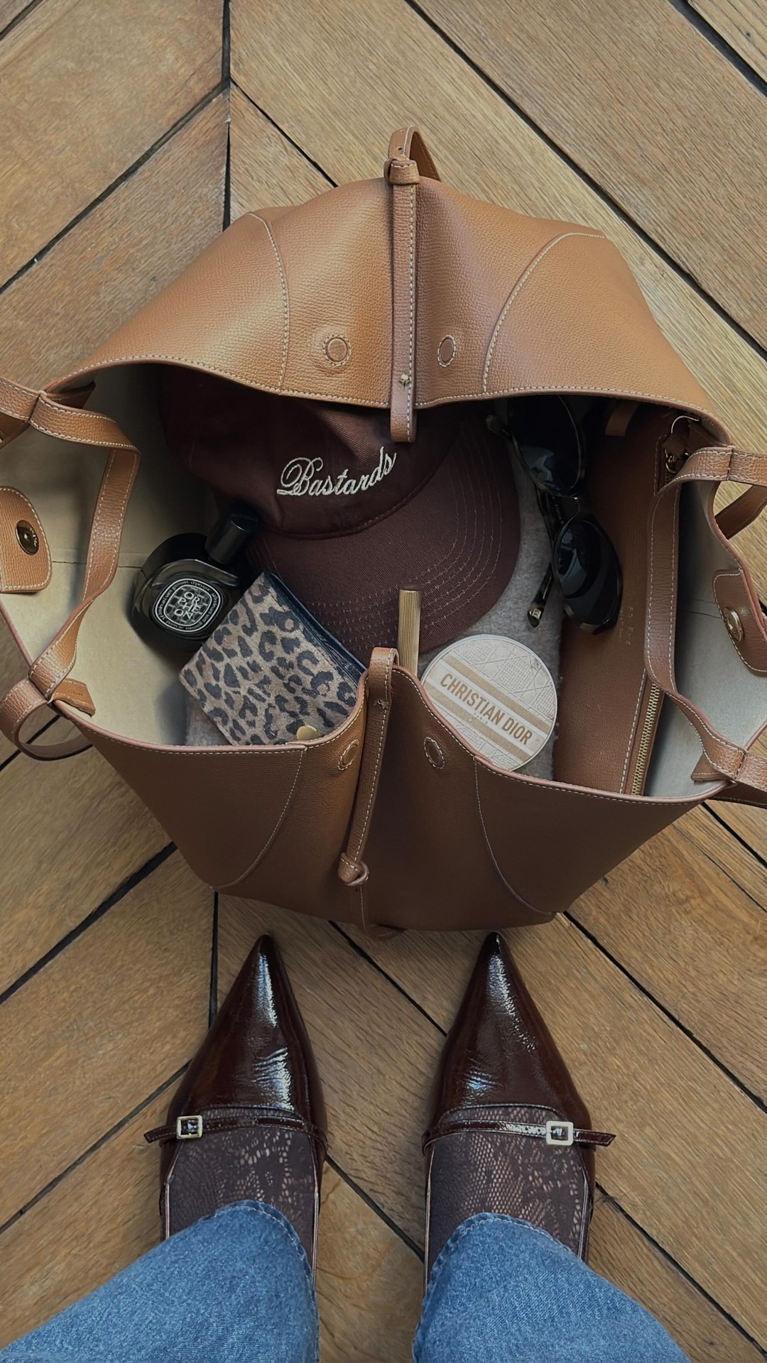 Open bag with cap, perfume, makeup inside