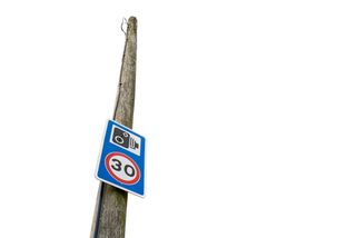 30 mph and speed camera warning sign seen fixed to a telegraph pole
