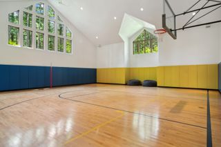 An indoor basketball court at a home for sale.