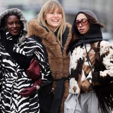 guests at Copenhagen Fashion Week wearing colorful and animal print coats in street style