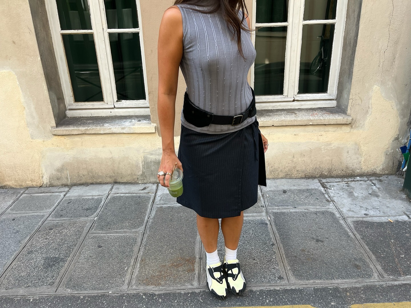 Influencer @_paulineleroy_ wears velcro trainers with a knee-length skirt and hip belt.