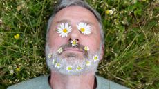 Mature man with daisies on his face and in his beard