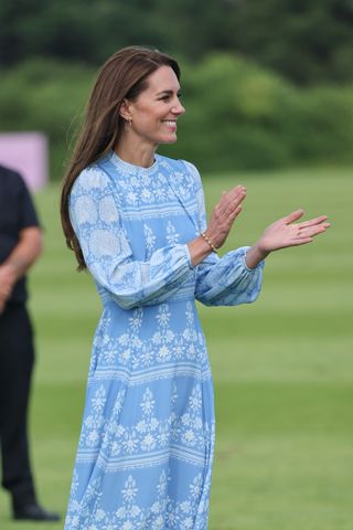 Kate Middleton in a blue and white dress at polo, clapping