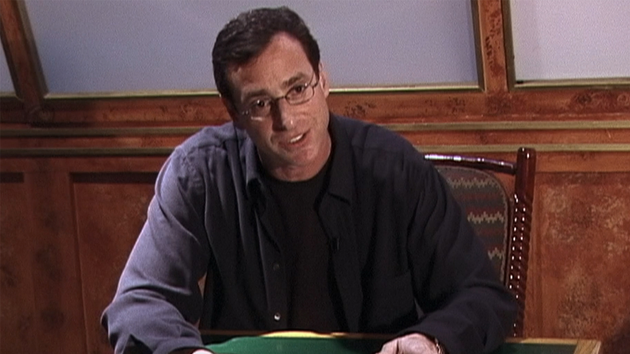 Bob Saget sitting at a table in The Aristocrats