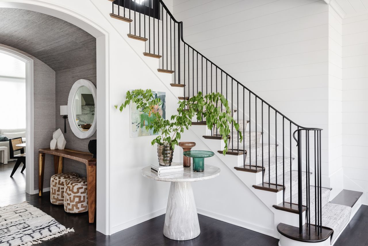 an entryway with a round table and console table