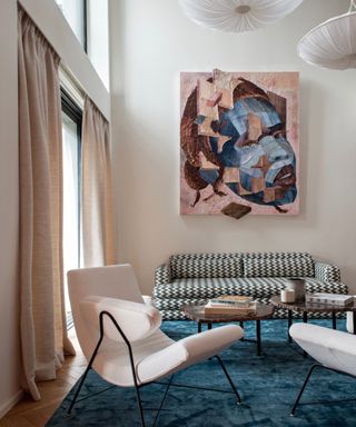 neutral living room with blue rug and colorful artwork