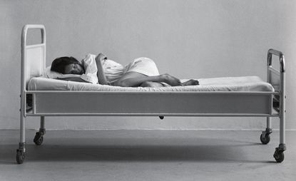 Black and white image of lady sleeping on bed