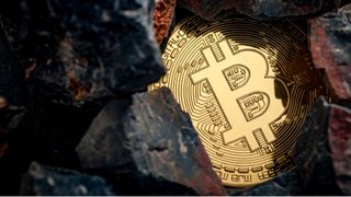 Abstract image of a bitcoin token inside some rocks to represent cryptocurrency mining