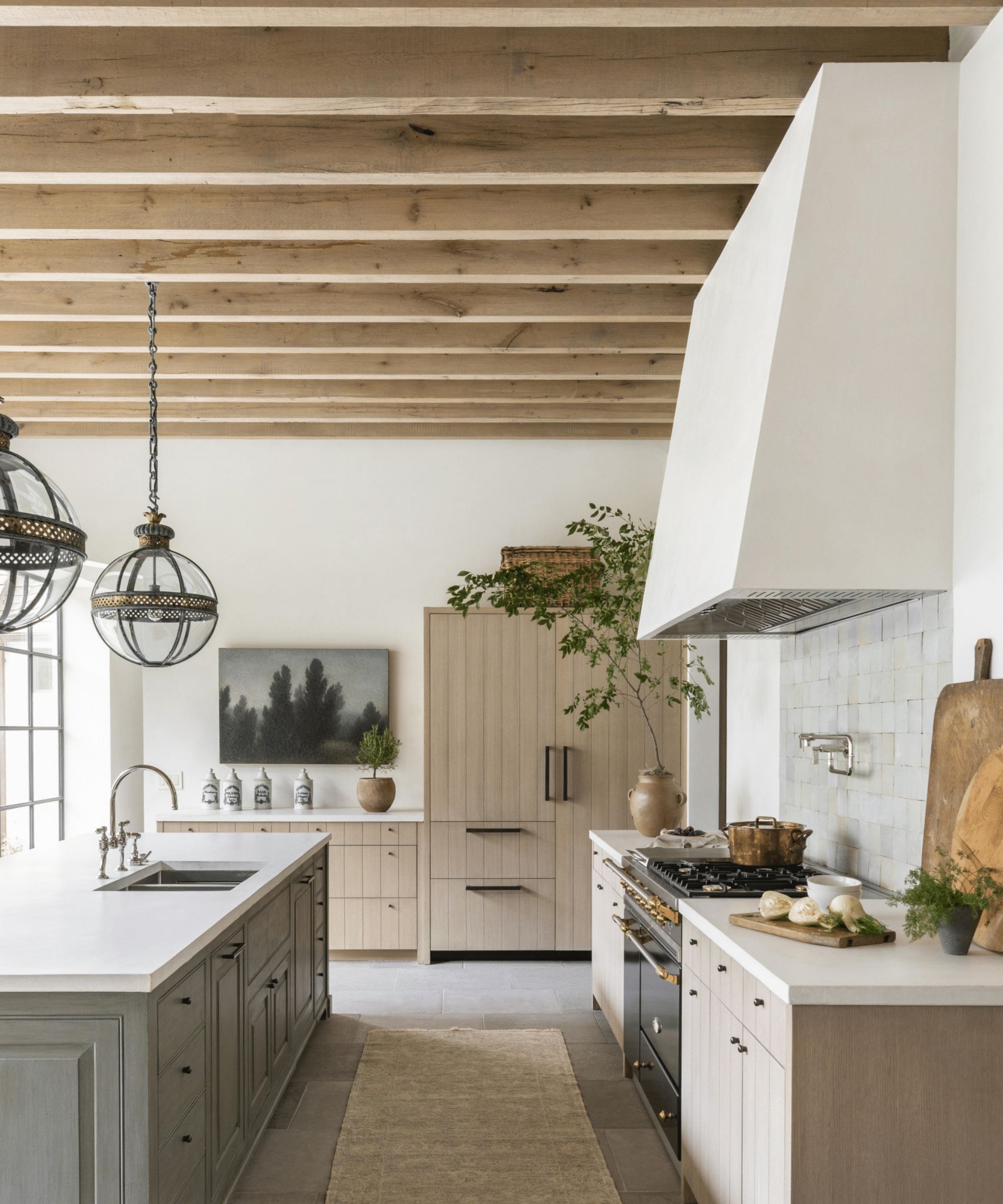 A warm neutral kitchen with wood cabinets and collected decor
