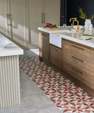 kitchen with patterned tile vinyl flooring, dark wood kitchen island with white countertop, beige painted kitchen cupboards