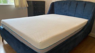 Simba Hybrid Ultra mattress shown on our reviewer's blue fabric bedframe