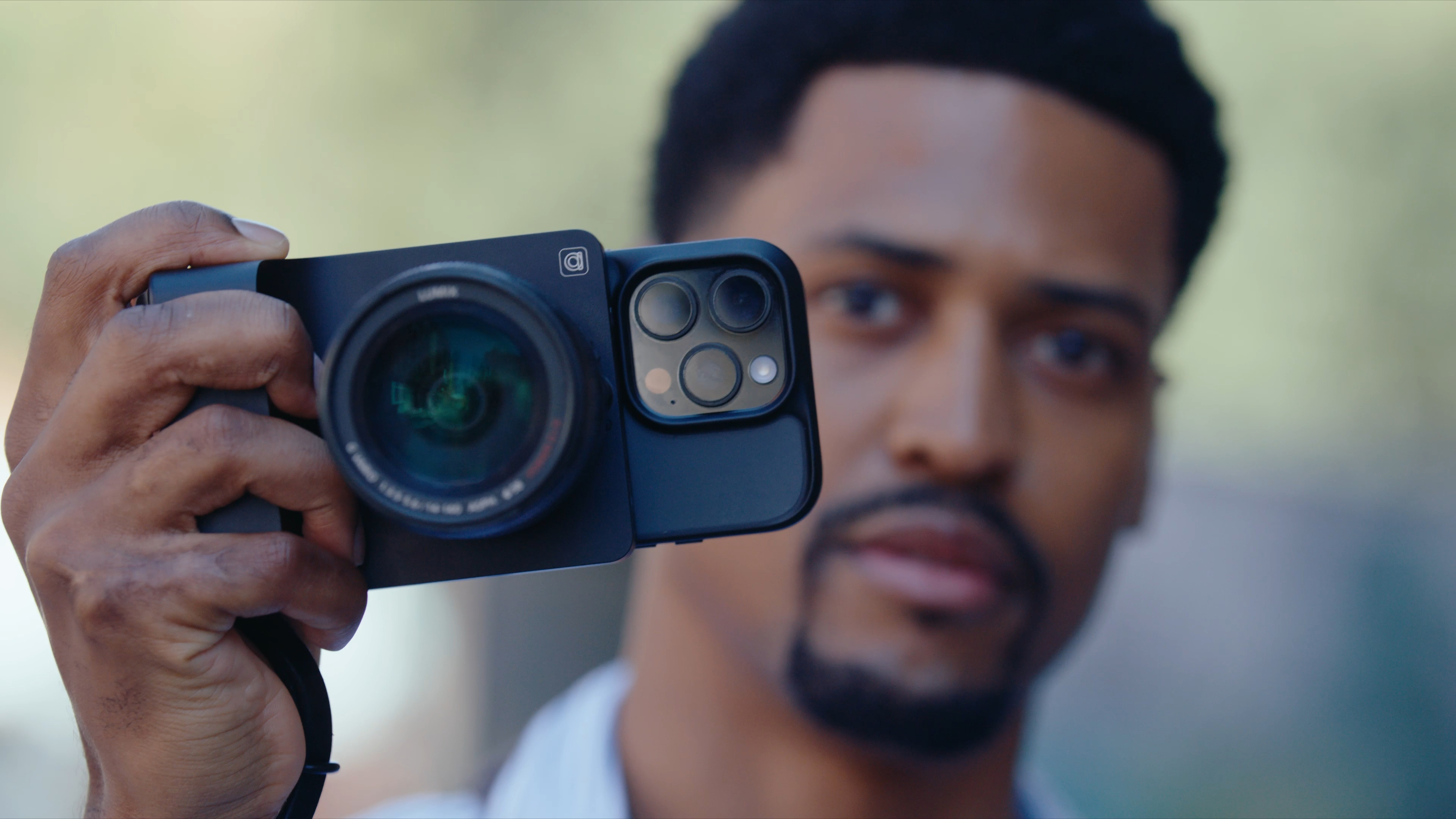 The Camera Intelligence Caira AI camera attached to an iPhone in a person's hands