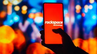 A hand holding a smartphone with the Rackspace logo on it
