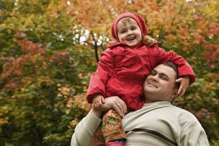 A man carries a girl in a park.