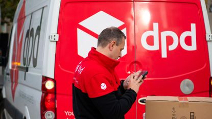 A DPD delivery driver scans a parcel in front of a DPD branded delivery van