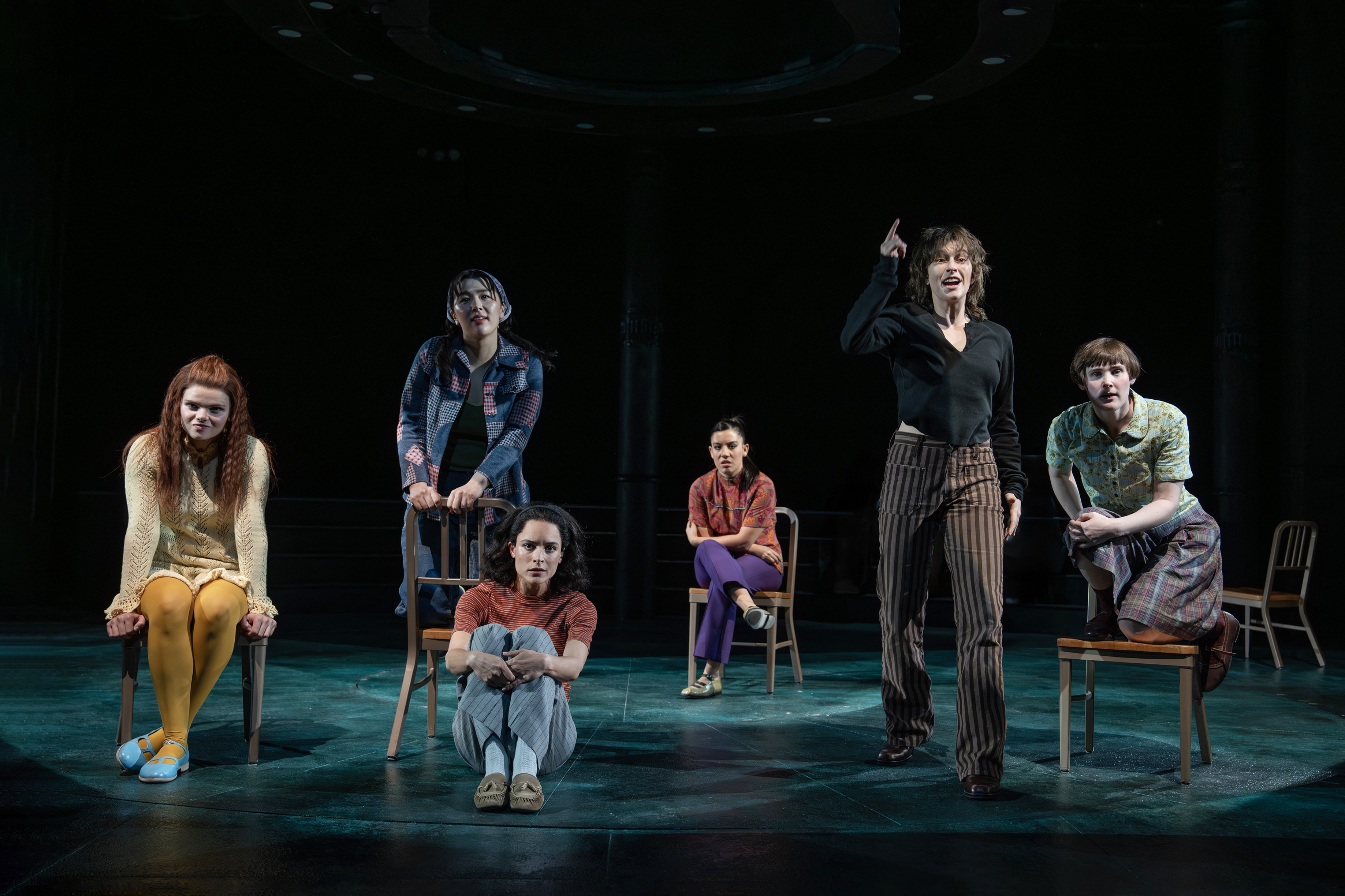 the cast of girl interrupted the off broadway musical on stage sitting in chairs during a musical number led by king princess as lisa