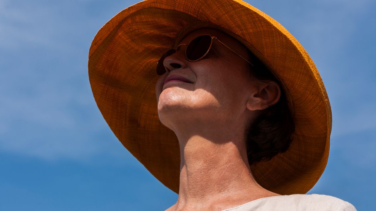 Smiling woman wearing summer hat and sunglasses