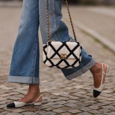 a woman walking with a Chanel handbag - best Chanel perfume