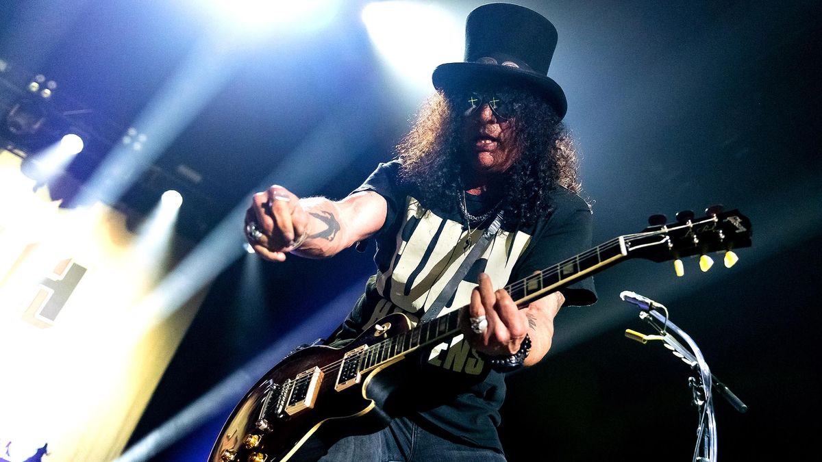 A top-hatted Slash plays a Gibson Les Paul onstage