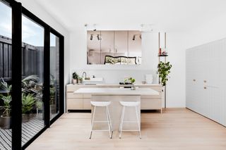 white kitchen with table top and wall mirror
