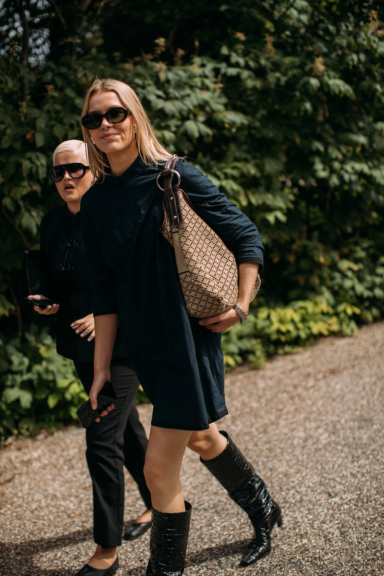 Woman in croc embossed boots and a black dress.