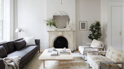 a stylish neutral living room with a marble fireplace and coffee table
