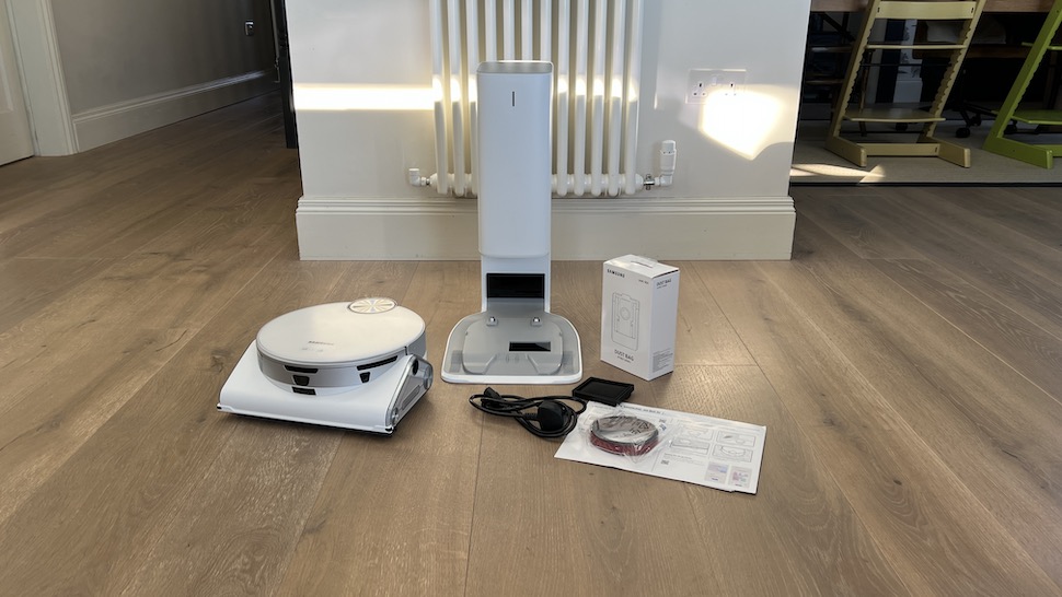 white robot vacuum box contents laid out on wood floor
