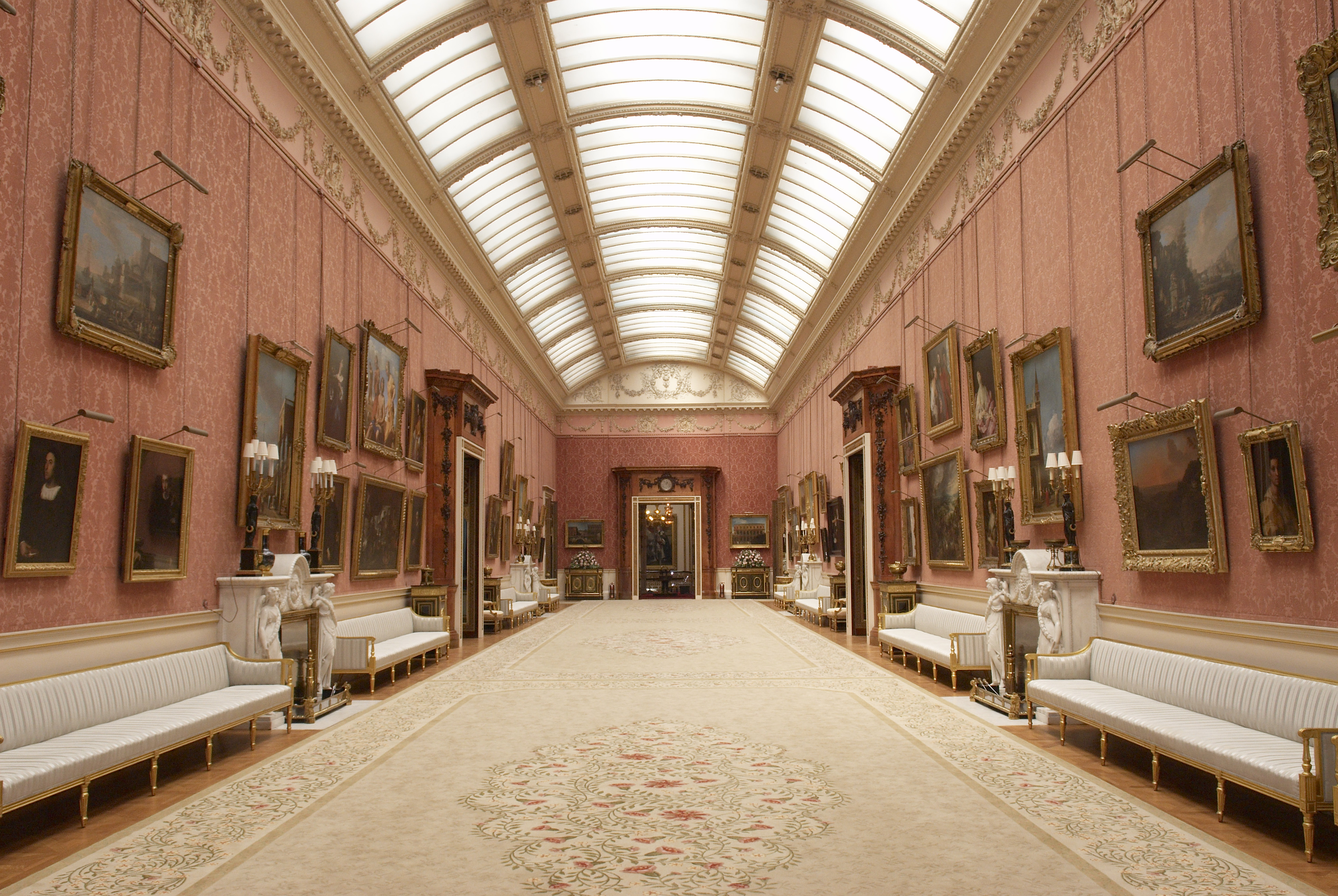 Peach coloured gallery room in Buckingham Palace lined in paintings