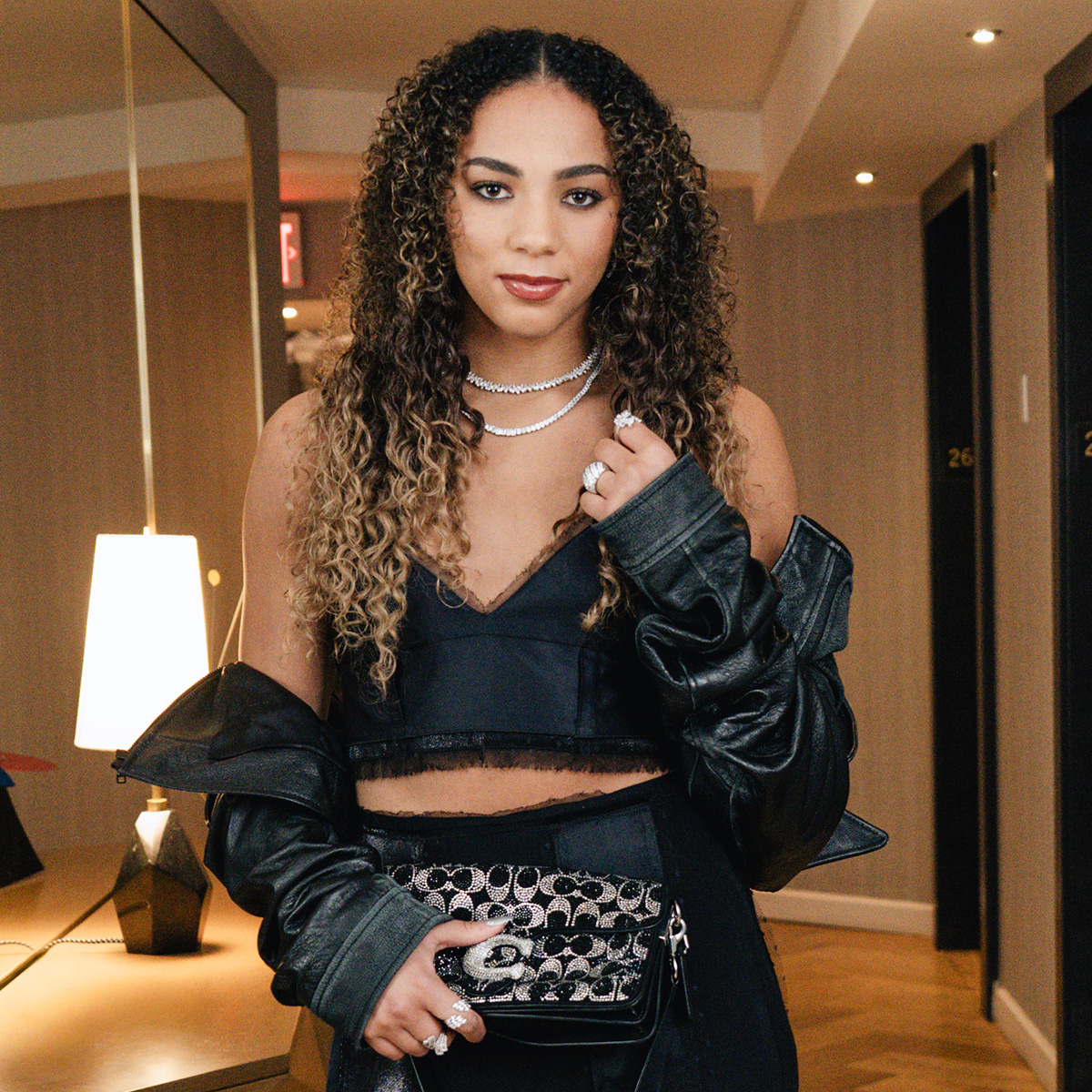 Kiki Rice getting ready for the 2026 WNBA Draft wearing a Coach set and bag. 