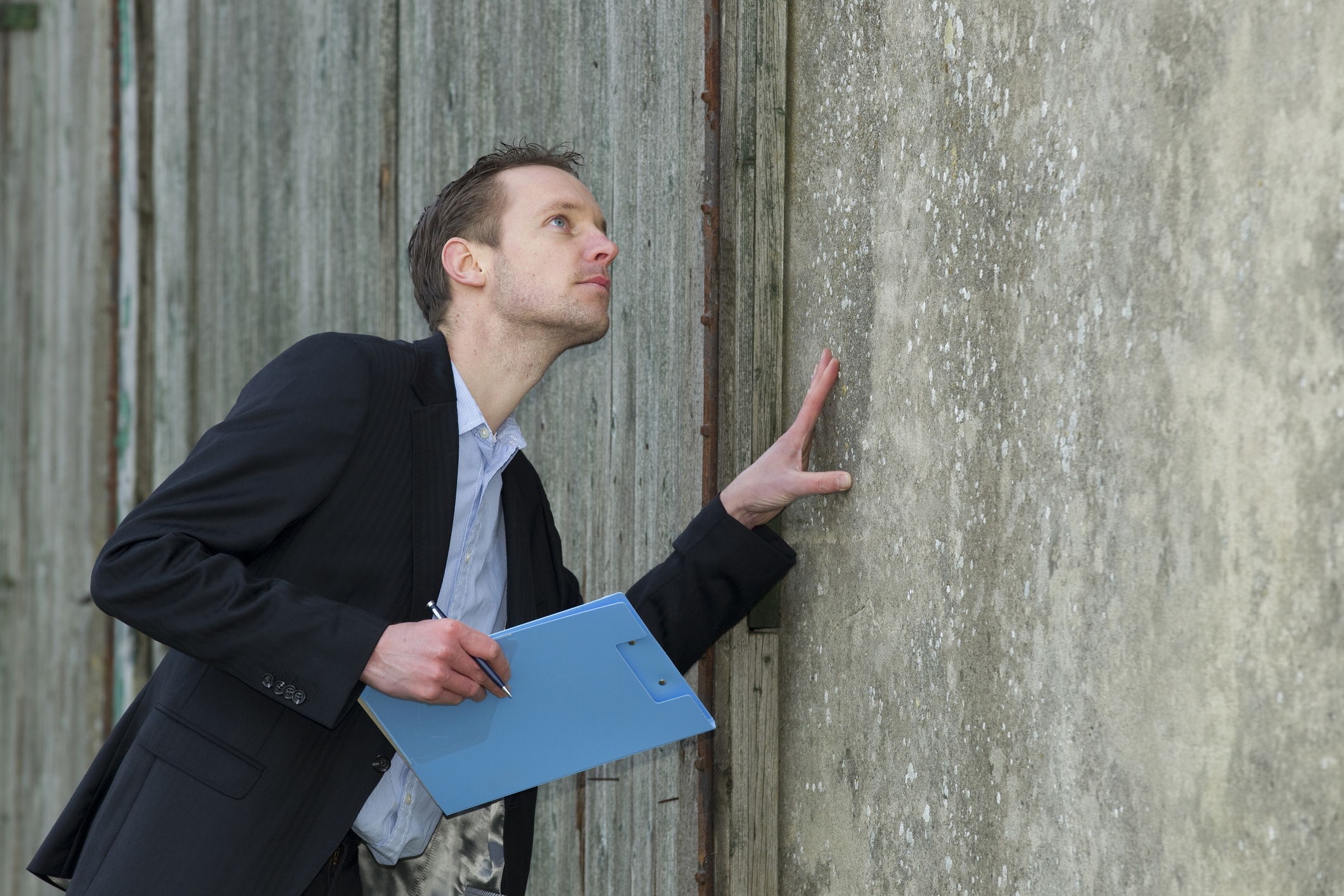 A surveyor inspecting the outside of a home during a building survey