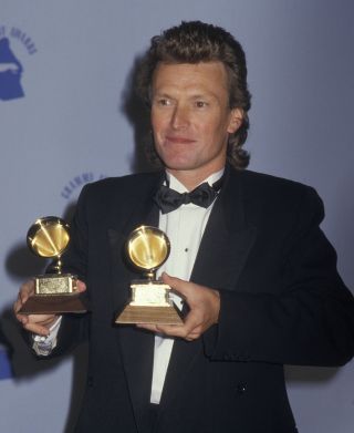 Back in the high life: Winwood collecting his Grammys in Los Angeles in 1987