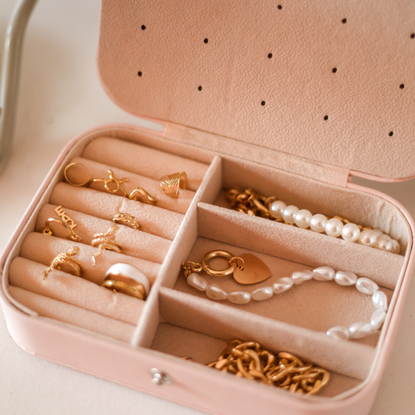 Pink jewellery box containing gold jewellery