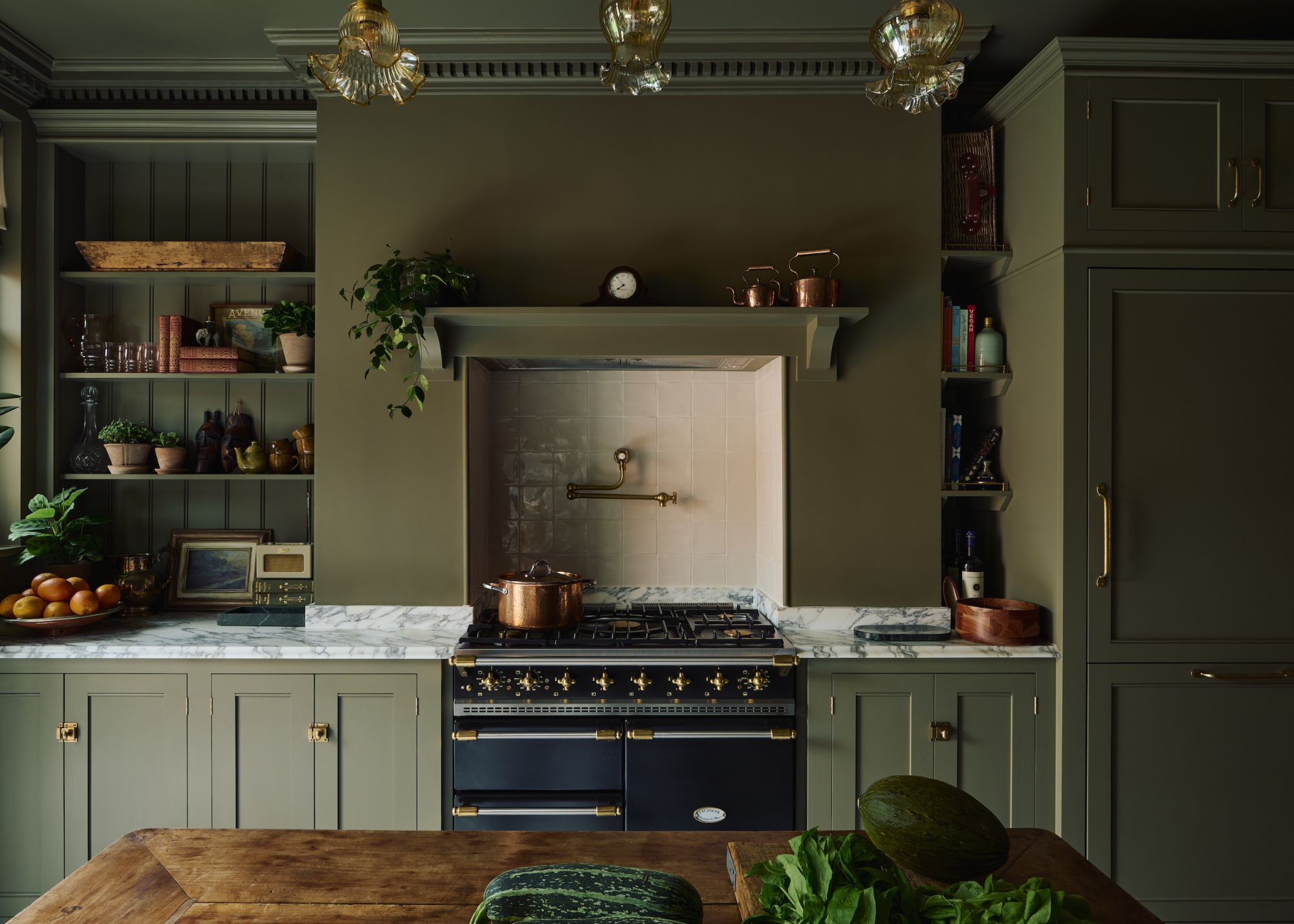 A traditional green kitchen with brass and copper details