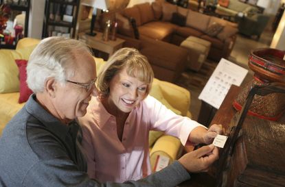 High angle view of a senior couple looking at a price tag in a furniture store