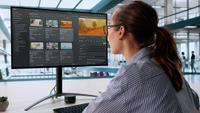 Woman looking at a computer screen while editing video