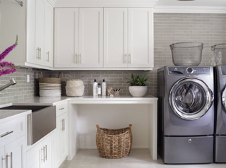 Utility room with additional storage space for baskets. There is a basket under the countertop and baskets on top of the counters.