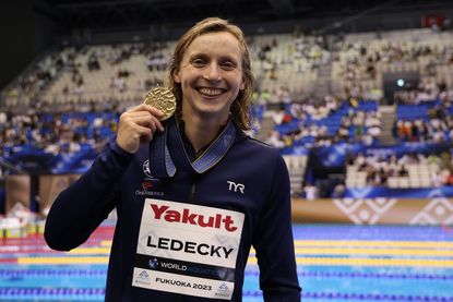 Katie Ledecky poses with her gold medal in the 800m women's freestyle. 