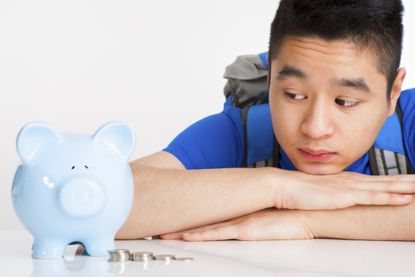 Teenager student with blue piggy bank