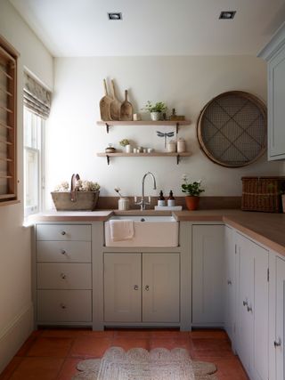 utility room corner with pale blue cabinets and quarry tiles and vintage accessories