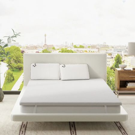 A Panda London mattress topper and two pillows on a Panda London mattress with the bed in front of an outdoor view